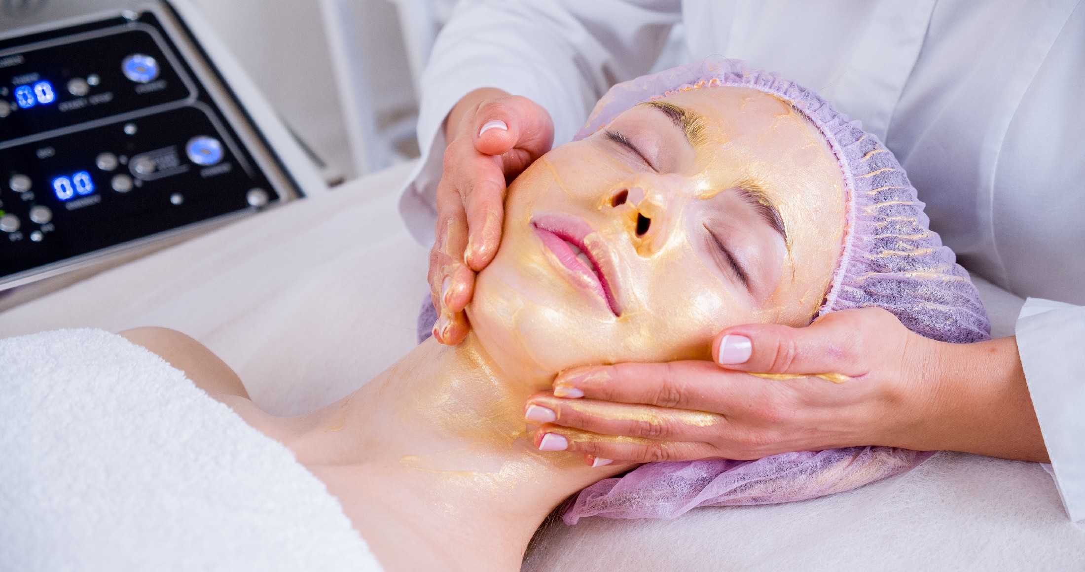 Cosmetologist Applies A Woman A Therapeutic Mask On Her Face. Wo
